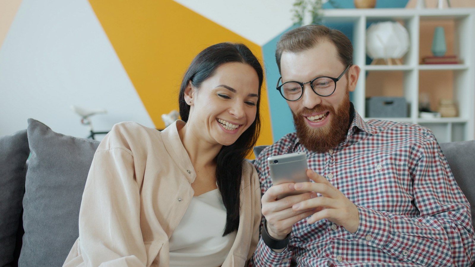 Couple reviewing WhatsApp messages together on a smartphone as relationship evidence for a spouse visa